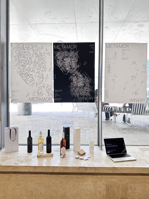 METAMOR exhibition presentation with posters and bottles
